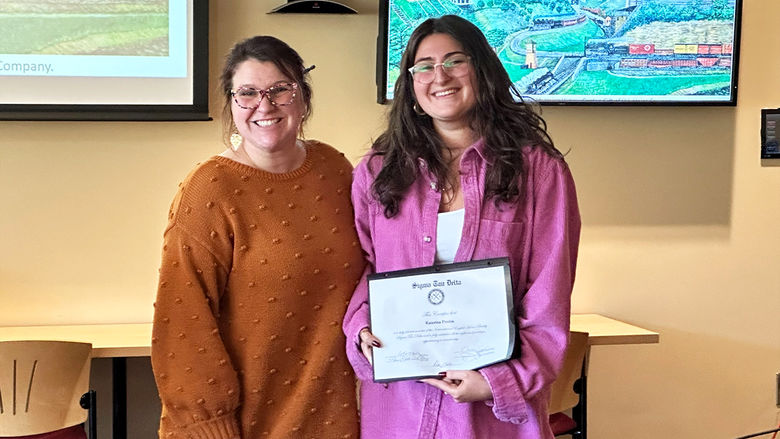 Katerina Poulos (right) is inducted into the Sigma Tau Delta English national honor society by Jeannette Lang, assistant teaching professor of English.