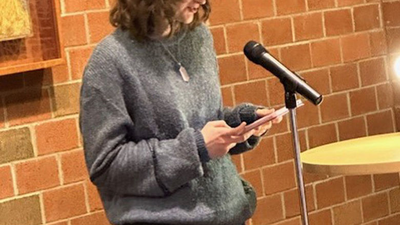 Student Kathryn Maille reads one of her poems.