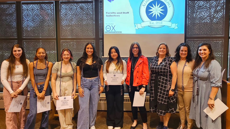 Ten students, faculty, and staff pose for a photo after being inducted into Tri-Alpha, an honor society for first-generation college students.