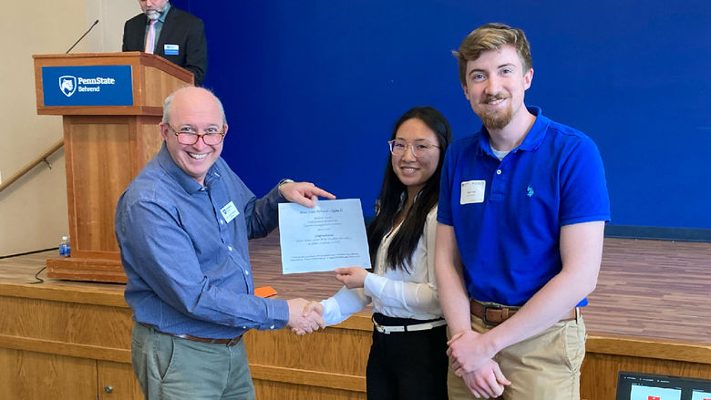 Tyler Frye and Rachel Kosaka receiving an award at the spring 2022 Undergraduate Research and Creative Accomplishment Conference