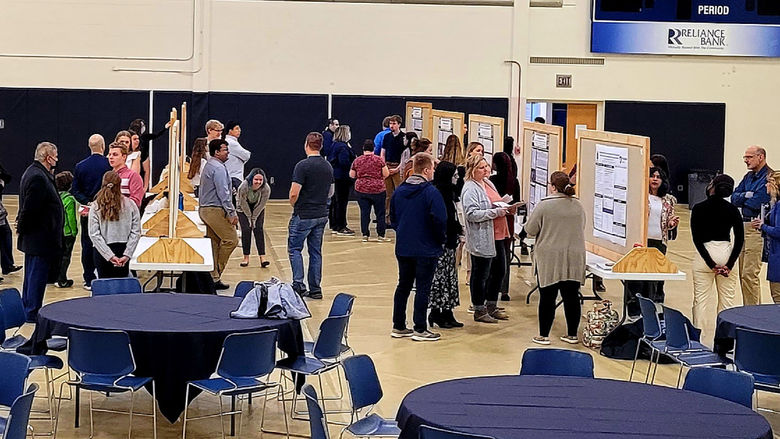 Students, Faculty, and Staff attend the Undergraduate Research and Creative Activities Fair in the gymnasium of the Adler Athletic Complex