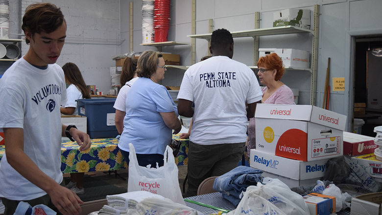 Student work with community members as part of the Voluntoona community service effort