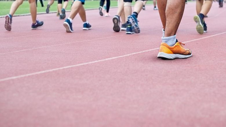 A group of people all walking on a track