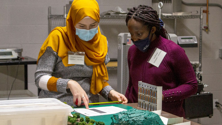 Two female engineering students work on a project as part of the 2021 Women in Engineering competition