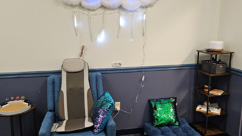 A massage chair with a zen sand garden and cushions next to it