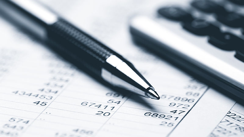 A pen and a calculator on top of tax documents