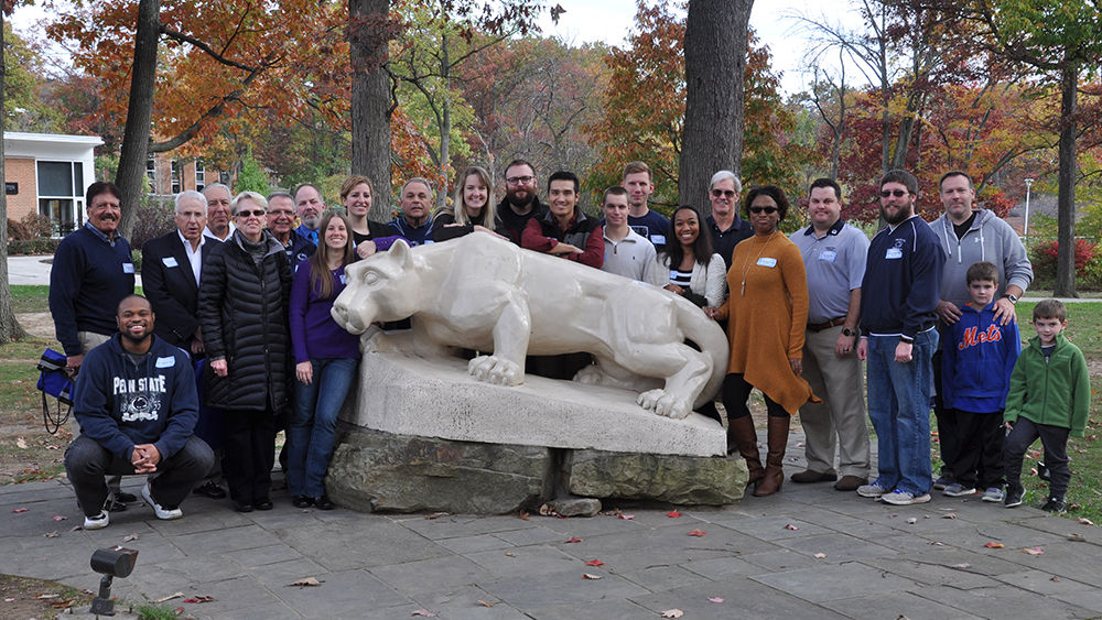 Penn State Altoona alumni varsity athletes pose with the lion shrine