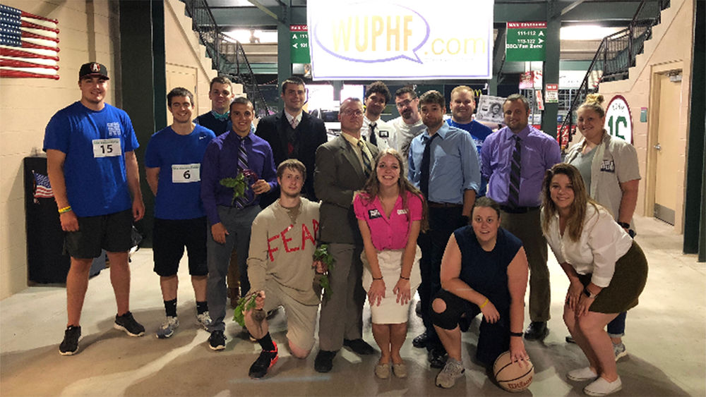 Scarcelli, center with white shirt and black tie, poses with several other interns at the Altoona Curve.