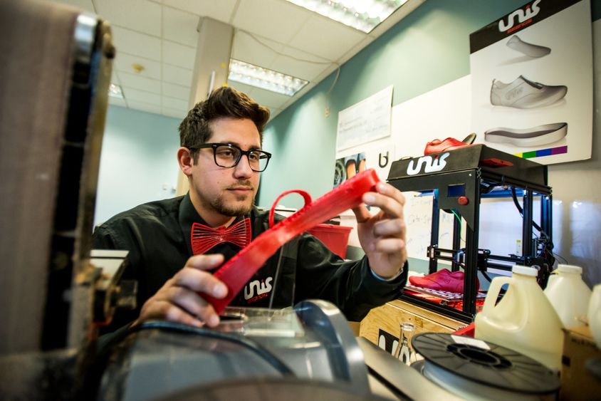 Nicholas Unis inspects a piece of his 3D-printed custom sneaker.