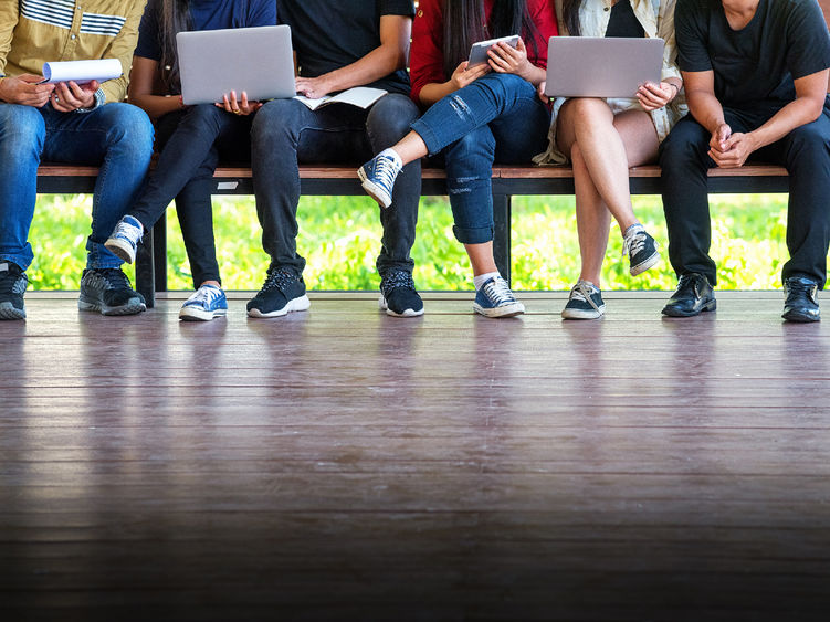 People sitting on a bench studying