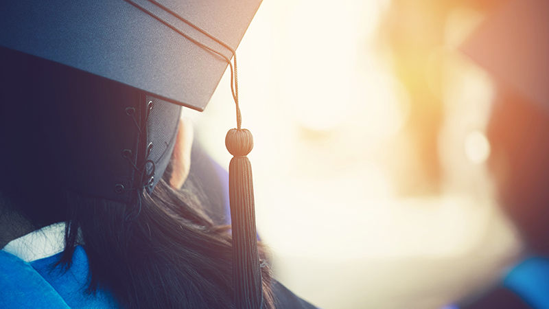 Close up image of female graduate in cap from behind