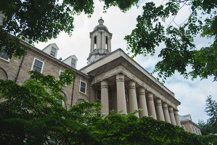Photograph of Old Main surrounded by summer foliage