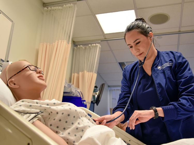 Paola Jaramillo Calderon interacts with a mannequin in Penn State Altoona's nursing simulation lab.