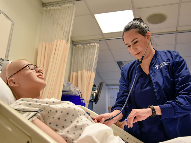 Paola Jaramillo Calderon interacts with a mannequin in Penn State Altoona's nursing simulation lab.