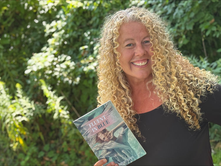 Penn State Altoona Professor Erin Murphy holding a copy of her latest book Fluent in Blue