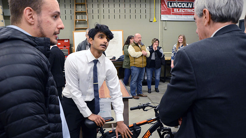 A student in the Electro-Mechanical Engineering Technology program demonstrates his project at the Student Showcase