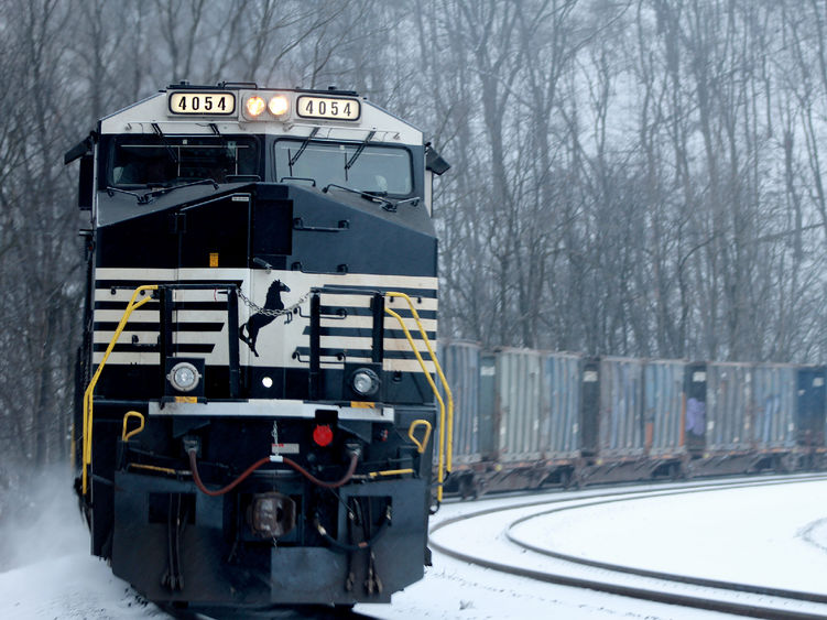 A snow-covered train making a turn on tracks