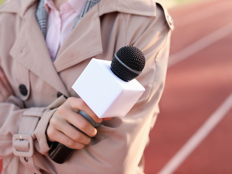 a female sports reporter holding a microphone