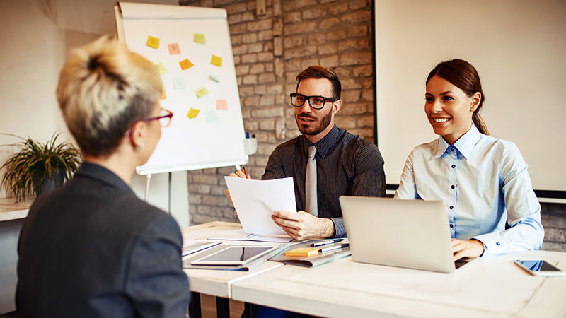 Stock photo of two young professionals interviewing a third