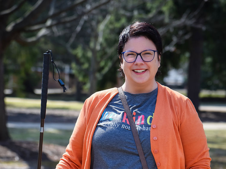 Jen Parrish walking on the Penn State Altoona campus holding her mobility cane.