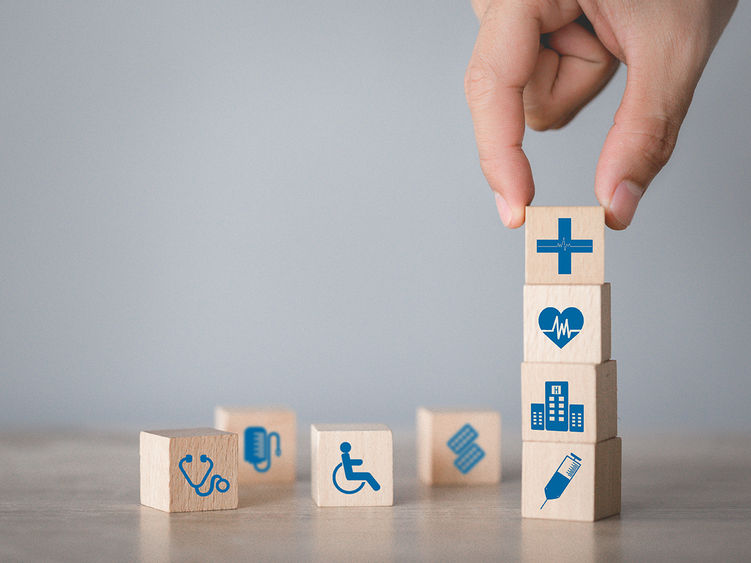 Stacking wooden blocks that represent different aspects of health professions