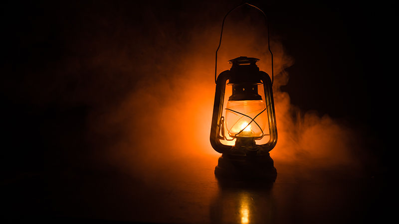 a lantern emitting orange light in the darkness