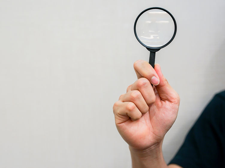 close up man hand holding magnifier glass for searching background concept