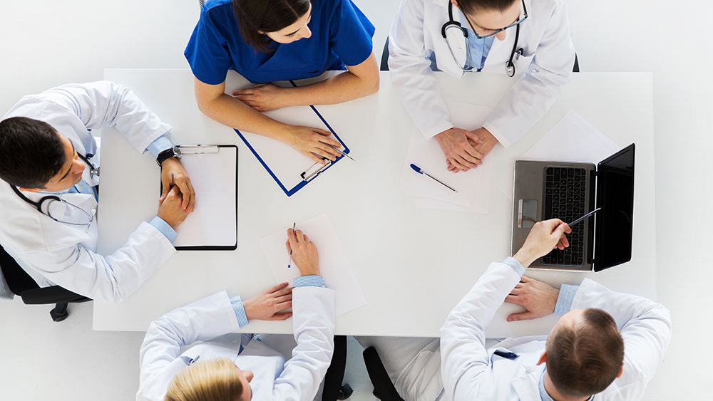 Doctors and nurses sitting around a table