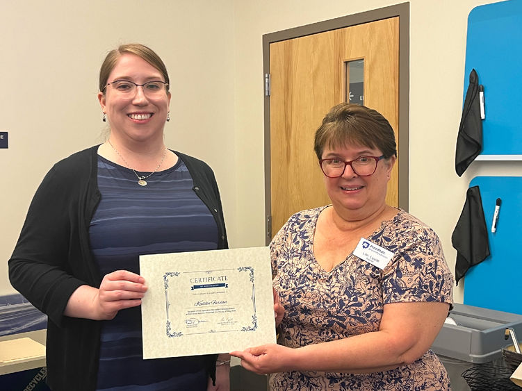 Kaitlin Farnan (L) is presented with an award certificate by Lori Lysiak, reference and instruction librarian at Eiche Library.