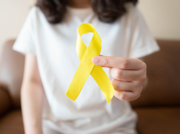 A girl holding a yellow ribbon symbolizing suicide prevention