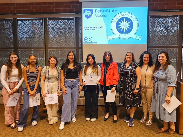Ten students, faculty, and staff pose for a photo after being inducted into Tri-Alpha, an honor society for first-generation college students.