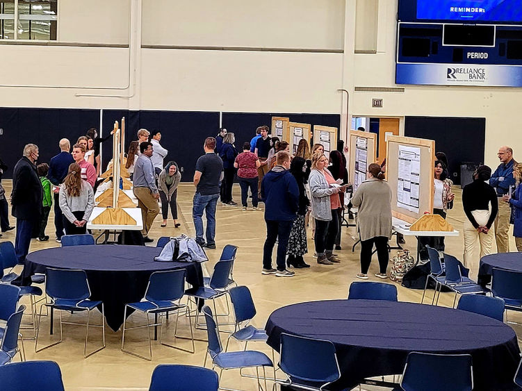 Students, Faculty, and Staff attend the Undergraduate Research and Creative Activities Fair in the gymnasium of the Adler Athletic Complex