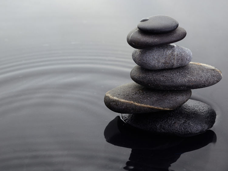 A stack of stones in a shallow pool of water